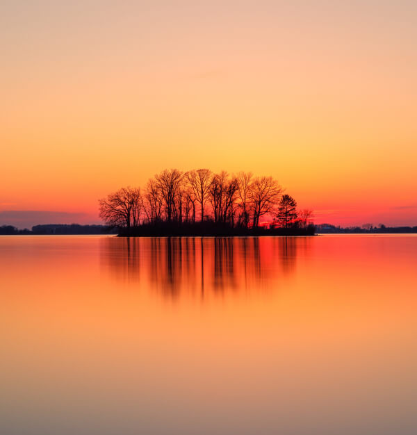 Sonnenuntergang über stillem Wasser — Sinnbild für Weitsicht und Ruhe